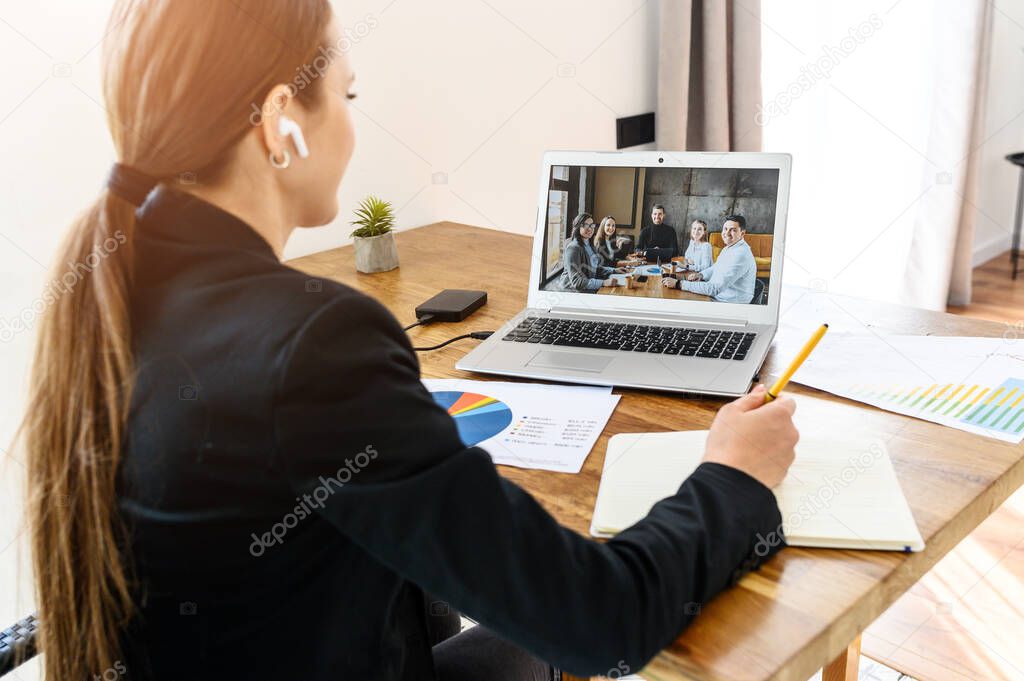 A young woman connects via video with coworkers