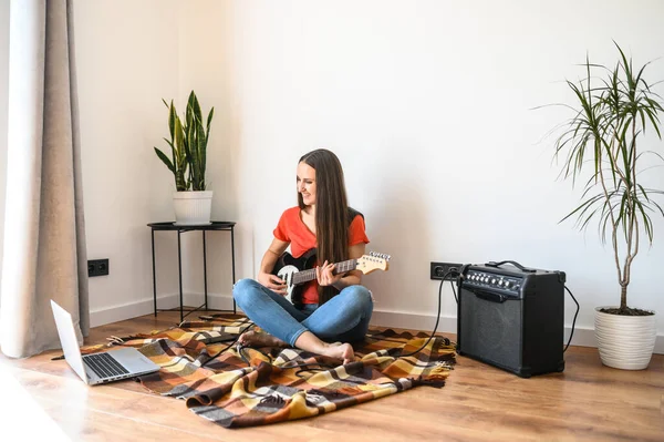 Giovane donna impara a suonare la chitarra elettrica — Foto Stock