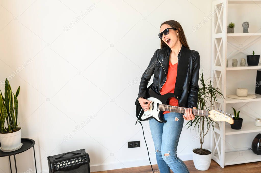 Woman in leather jacket playing an electric guitar