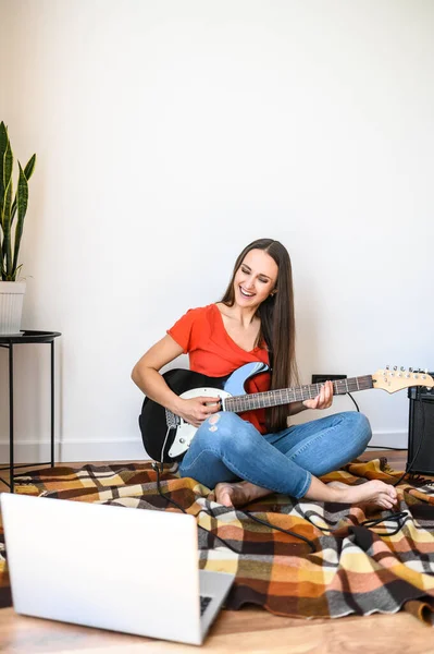 Giovane donna impara a suonare la chitarra elettrica — Foto Stock