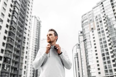 Spor kıyafetli genç adam dışarıda antrenman yapıyor.