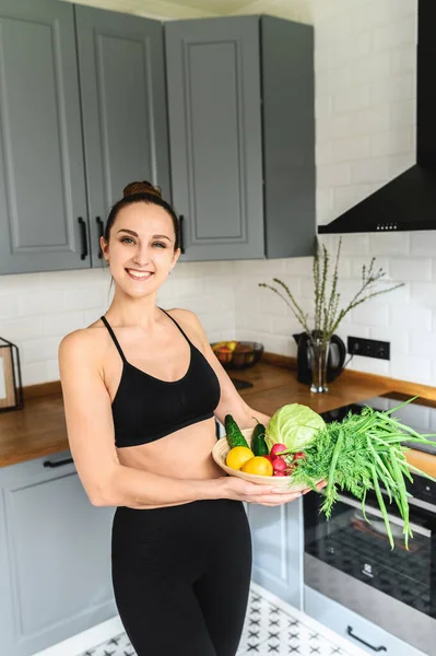 Giovane donna con verdure fresche in cucina — Foto Stock