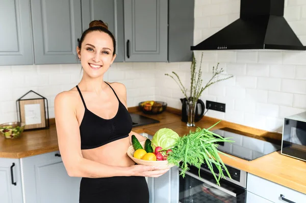 Giovane donna con verdure fresche in cucina — Foto Stock