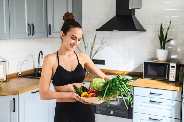 Jeune femme avec des légumes frais dans la cuisine — Photo