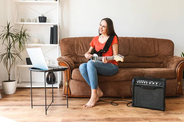 Una donna impara a suonare la chitarra elettrica a casa — Foto Stock