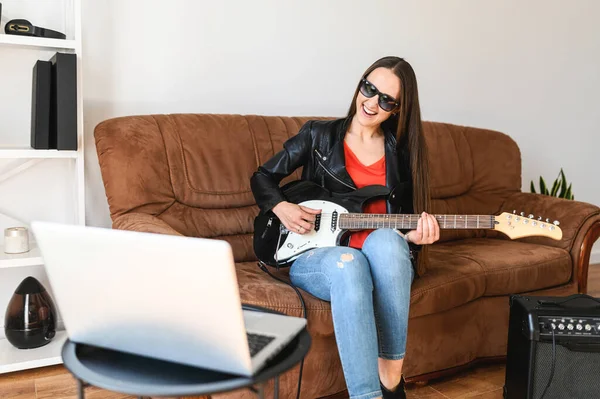 Una donna impara a suonare la chitarra elettrica a casa — Foto Stock