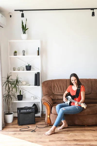 Una donna suona la chitarra elettrica a casa — Foto Stock