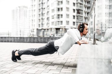 Spor kıyafetli genç adam dışarıda antrenman yapıyor.