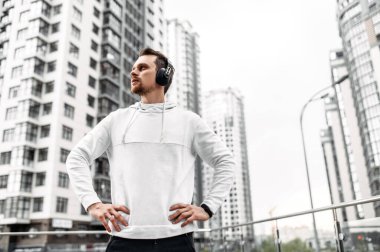 Spor kıyafetli genç adam dışarıda antrenman yapıyor.