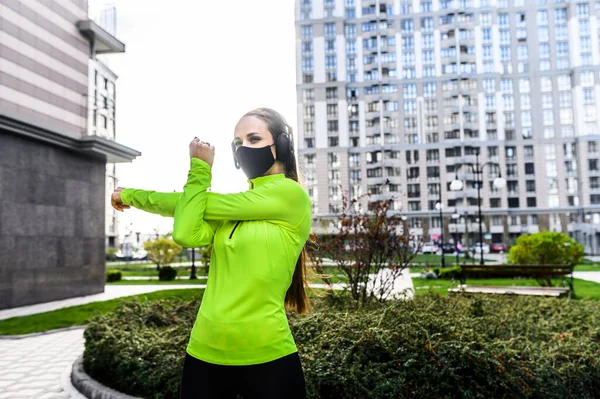 Жінка в спортивному одязі з медичною маскою на відкритому повітрі — стокове фото