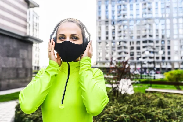 Γυναίκα σε αθλητικά με μαύρη ιατρική μάσκα — Φωτογραφία Αρχείου