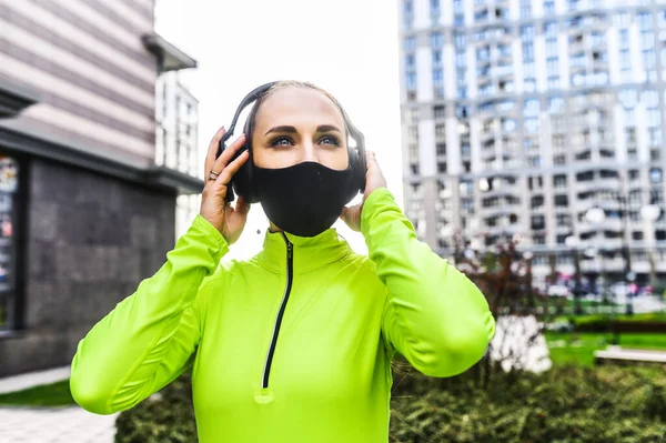 Woman in sportswear with a black medical mask — Stock Photo, Image