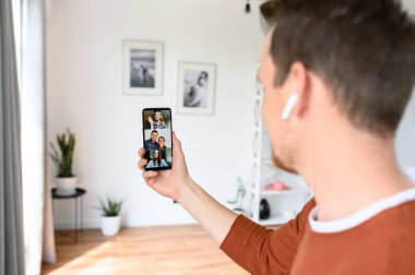 Bir adam video görüşmesi için akıllı telefon kullanıyor, zoom