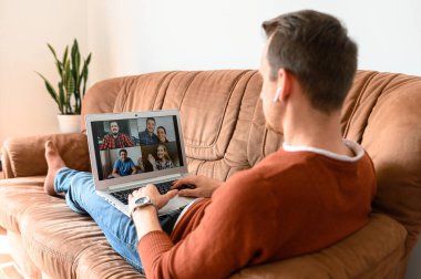 Adamın biri video görüşmesi için dizüstü bilgisayar kullanıyor.