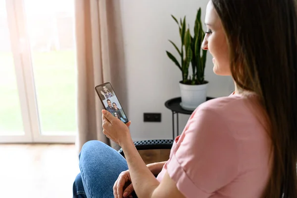 Молода жінка використовує телефон для відеодзвінків, збільшує — стокове фото