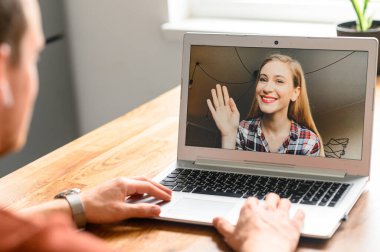 Adamın biri video görüşmesi için dizüstü bilgisayar kullanıyor.