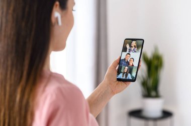 Görüntülü arama için telefon kullanan genç bir kadın, zoom