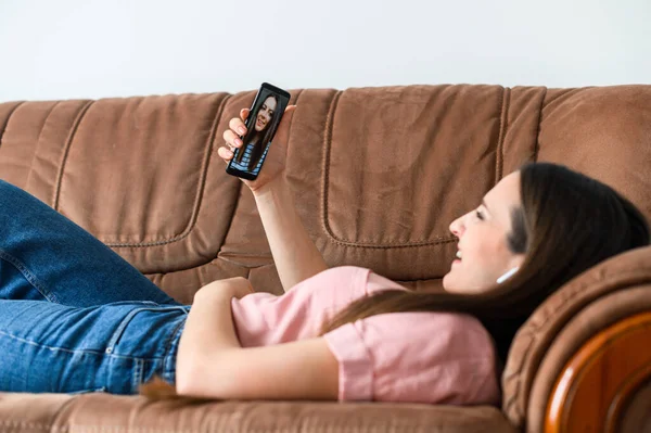 Una chica está utilizando el teléfono inteligente para videollamadas, zoom —  Fotos de Stock