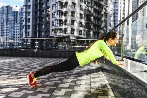 Vrouw in sportkleding is aan het sporten buiten — Stockfoto