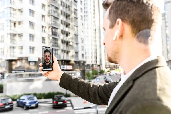 Un joven empresario tiene videollamada al aire libre —  Fotos de Stock