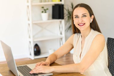 Genç bir kadın uzaktan kumanda için dizüstü bilgisayar kullanıyor.