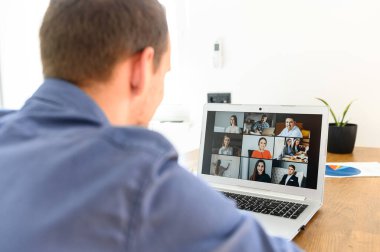 Bir adam video bağlantısı için bilgisayarda uygulama kullanıyor