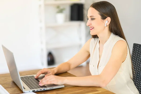 Une jeune femme utilise un ordinateur portable pour un travail à distance — Photo