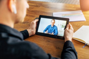 Ofiste elinde tablet olan erkek elleri, video çağrısı.