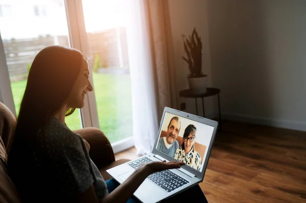 Een meisje heeft een videovergadering met een ouders — Stockfoto