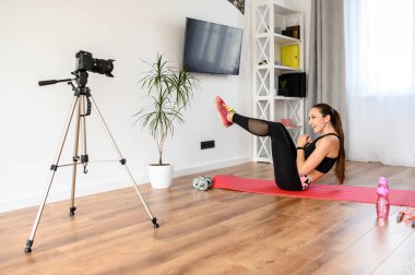 Genç bir kadın spor videoları kaydediyor.