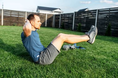 Genç bir sporcu karın kası egzersizi yapıyor.