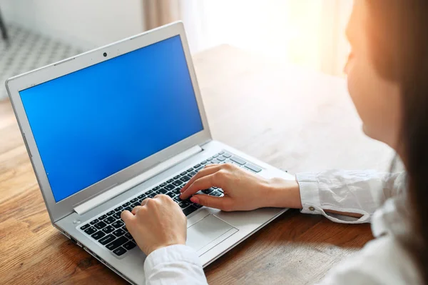 Una mujer joven en camisa blanca casual inteligente usando el ordenador portátil —  Fotos de Stock