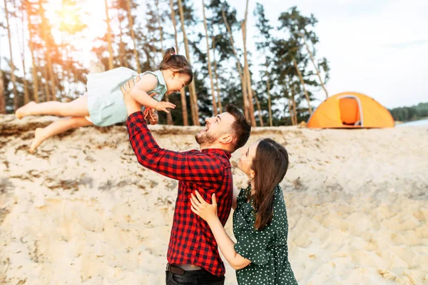 Ung familj tillbringar tid tillsammans i ett skogsläger — Stockfoto