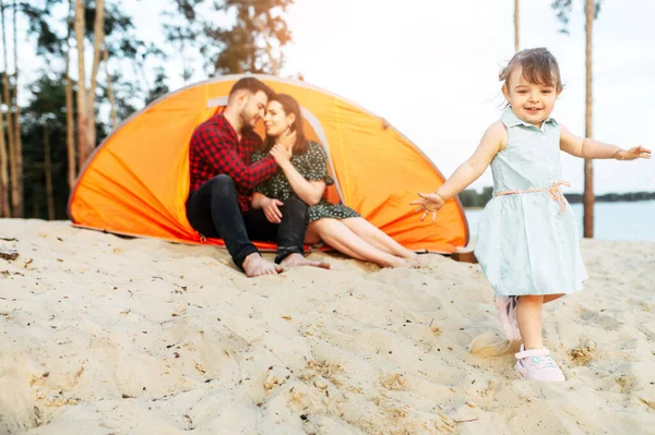 Young family spend time together in a forest camp