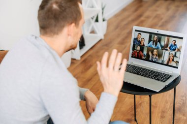 Video iletişimi için laptop uygulaması kullanan bir adam