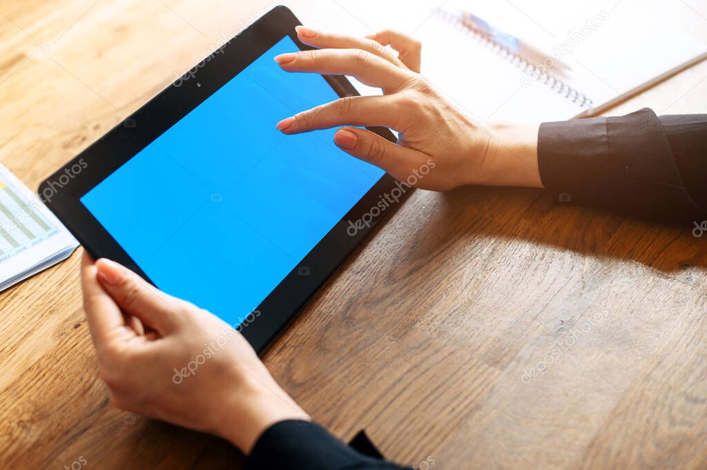 Female hands hold a tablet with blank screen
