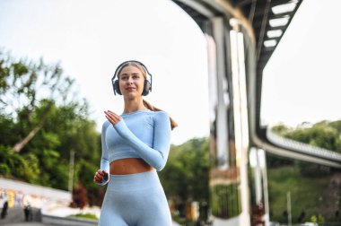 Genç bir kadın sokakta koşuyor.