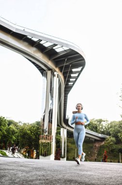 Genç bir kadın sokakta koşuyor.