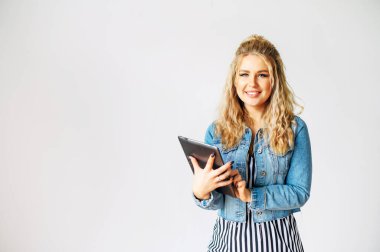 Güzel bir kadın tablet bilgisayar kullanıyor.
