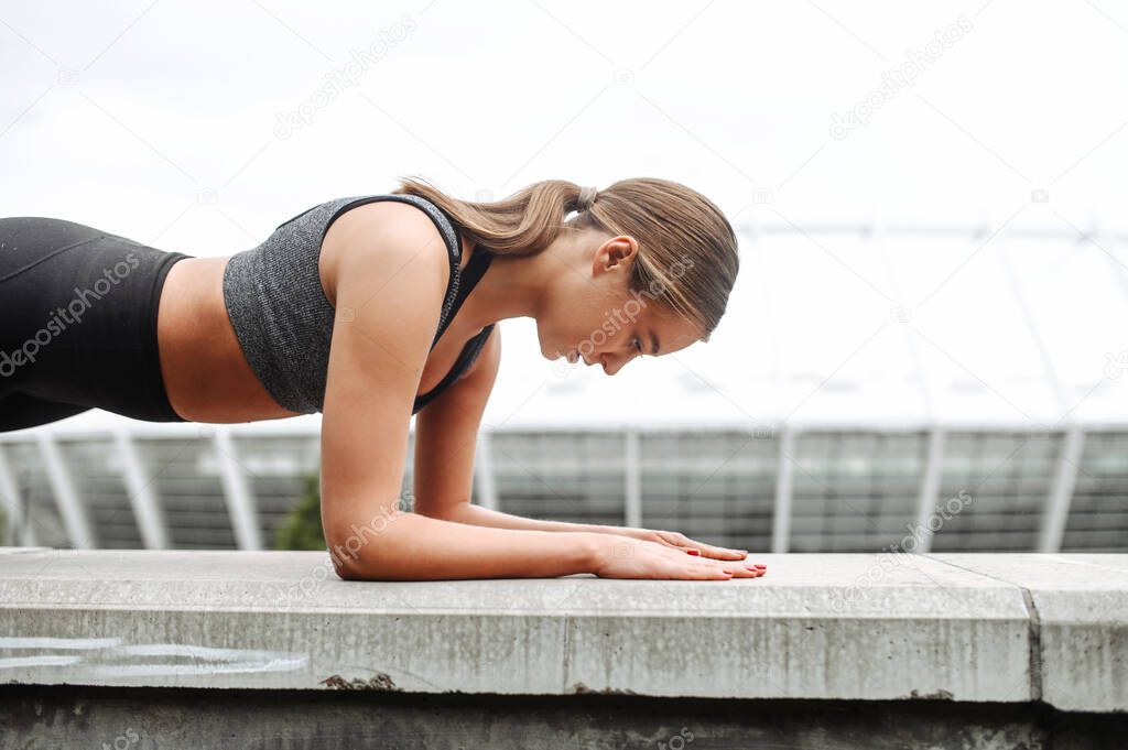 An athletic woman doing plank exercise outdoor