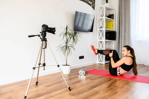 Genç bir kadın spor videoları kaydediyor.