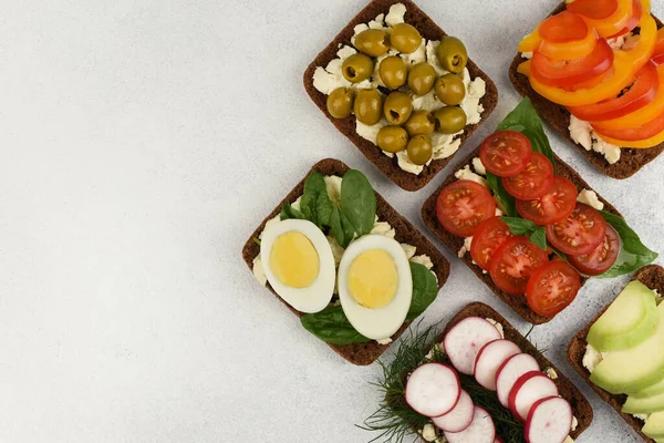 Open sandwiches on white stone background with copy space.