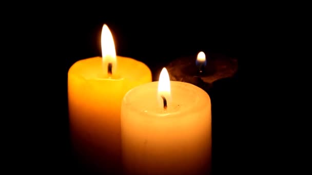 Drei Kerzen im Dunkeln, die endlich ausgeblasen werden — Stockvideo