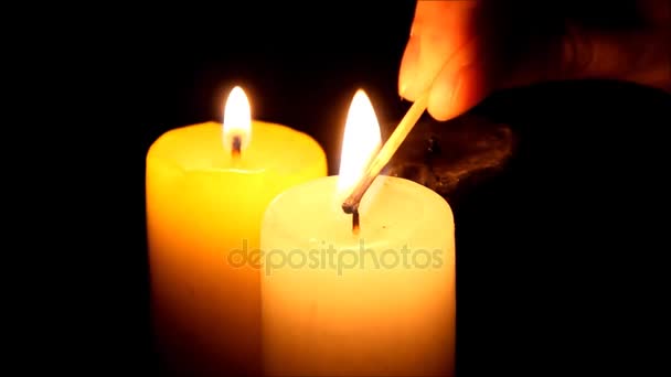 Drei Kerzen, die die Dunkelheit erhellen — Stockvideo