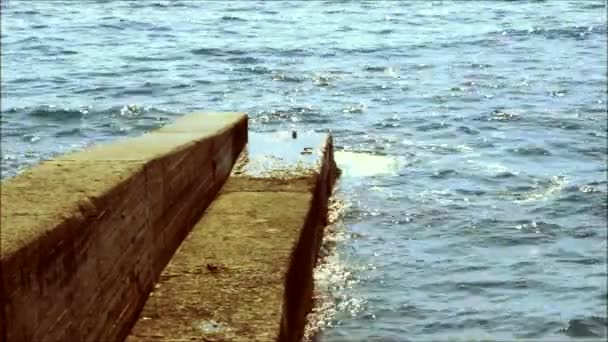 Golven slaan tegen een pier — Stockvideo