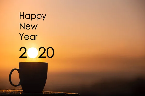 Xícara de café silhueta com feliz ano novo 2020 texto em um nascer do sol — Fotografia de Stock