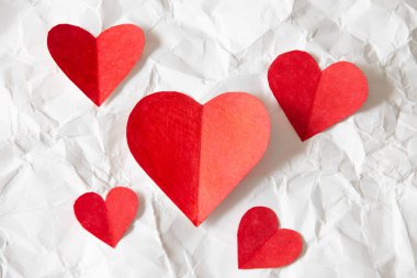 Kırmızılar kağıt üzerinde kırmızı kalpler, buruşmuş kağıt, sevgililer günü güzelliği.