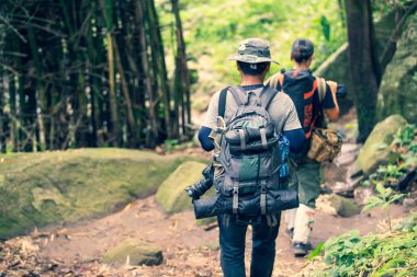 Grup arkadaşı ağır bir sırt çantasıyla vahşi doğada yürüyor. Seyahat L