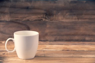 Tahta masaya beyaz kupa ve boşluğu kopyala