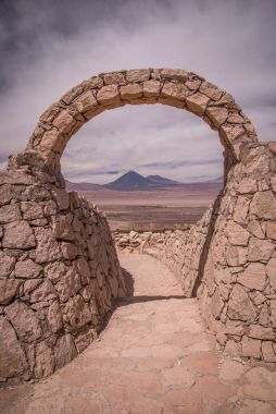 Pukara de Quitor - Inca Kalesi Atacama Çölü, Licancabur volkan Andes, San Pedro de Atacama, Chile adlı manzaralı taş kapıda